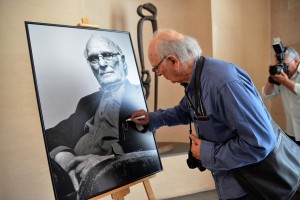 Carlos Saura realizando la tradicional firma de su retrato